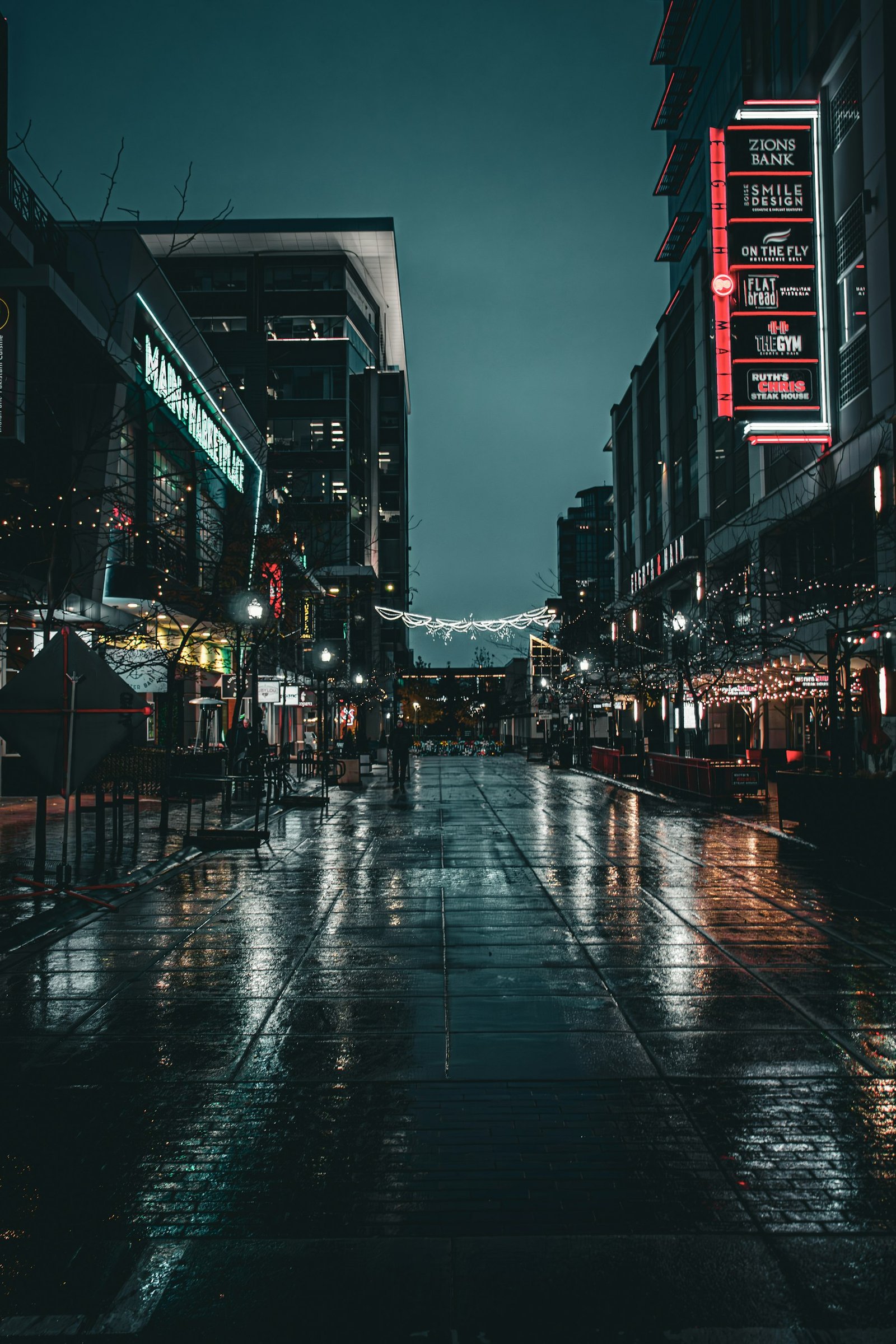 Downtown Boise at night with people walking among illuminated restaurants and city lights.