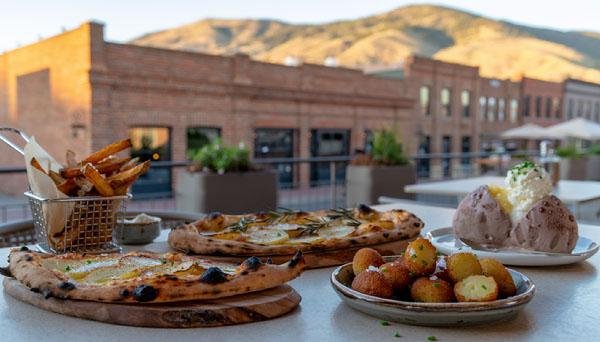 Potato pizza, fries, potato bites and an ice cream potato arranged on a restaurant table in Boise, Idaho.